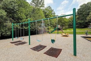 A playground with swings, a slide, and a climbing structure.