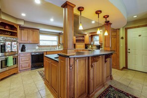 A kitchen with wooden cabinets, a stainless steel refrigerator, and a built-in oven. - Hot Tub & Mtn Views: Wolf Laurel Home (Mars Hill)