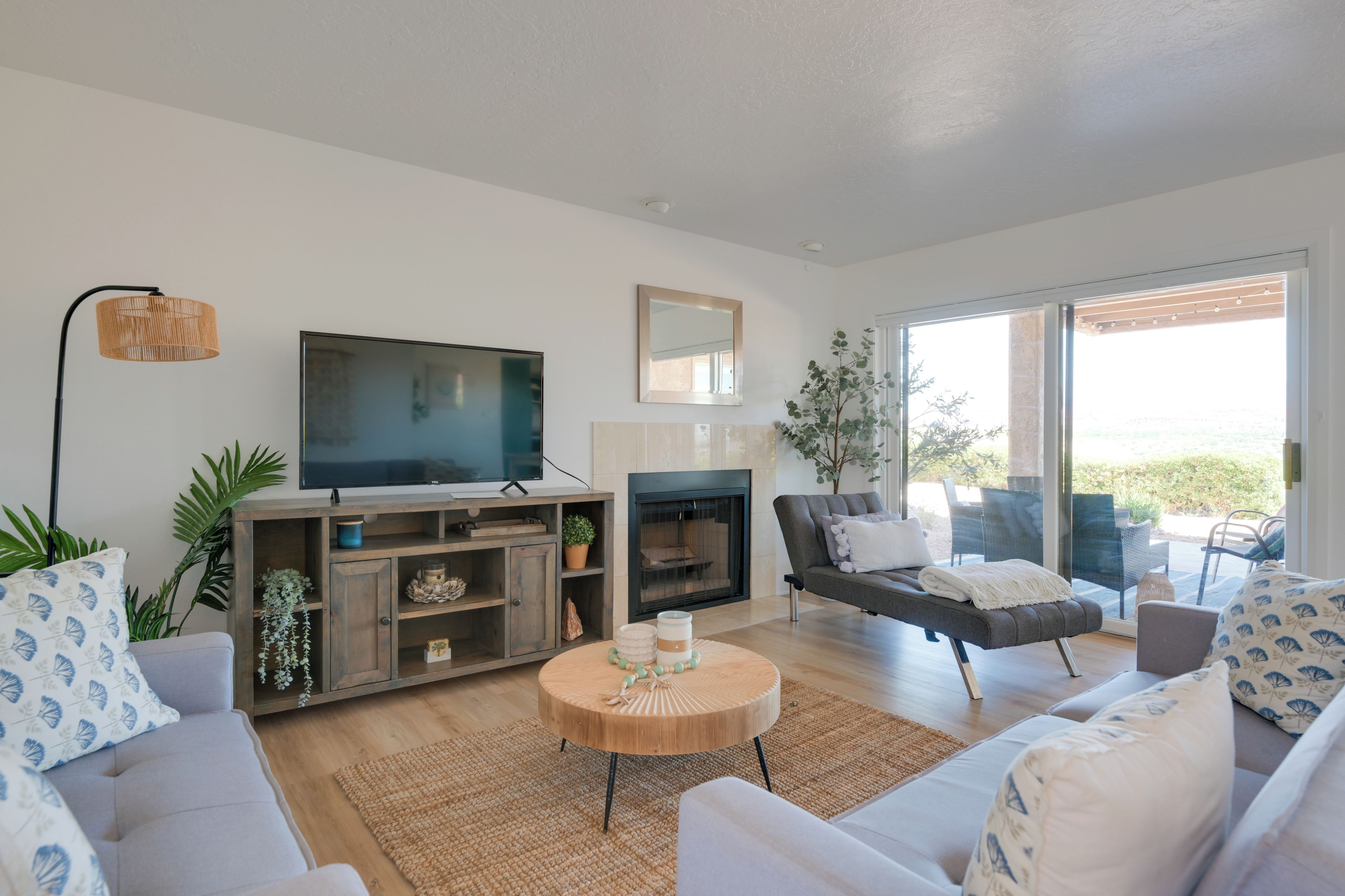Una sala de estar moderna con un televisor de pantalla plana, una chimenea y una zona de estar acogedora con sofá y sillones.