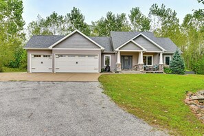 A two-story house with a garage, a covered porch, and a well-maintained lawn. - Hot Tub, Game Room & Steps to Pond! Elkhart Escape (Elkhart)