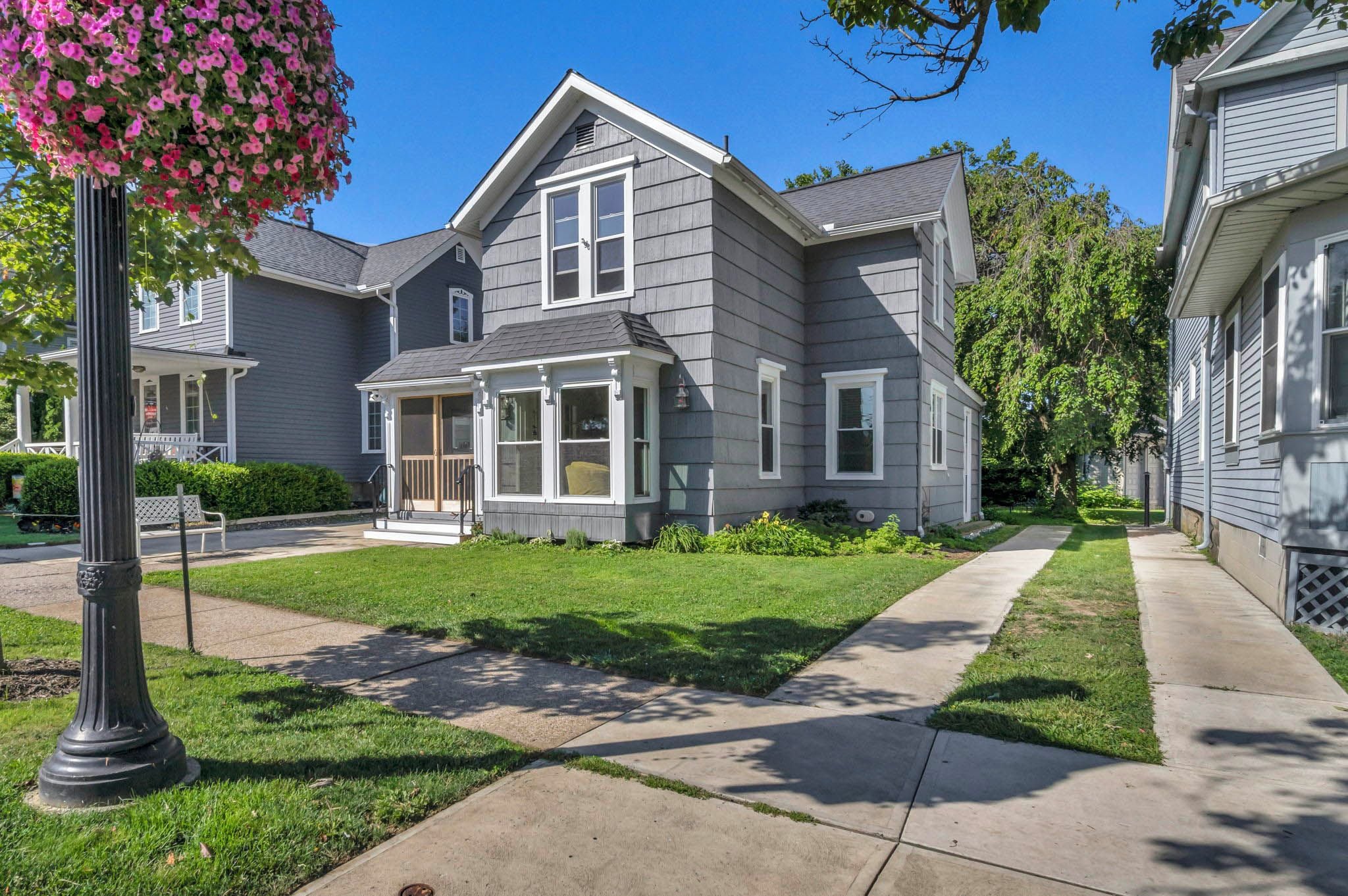 A residential house with a front porch, a covered entryway, and a well-maintained lawn.