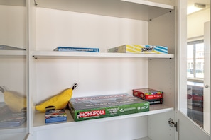 A shelf with various board games including Monopoly, Bananas, and Sorry! - Holiday at Alsea Bay: 1 Block to the Bay! (Waldport)