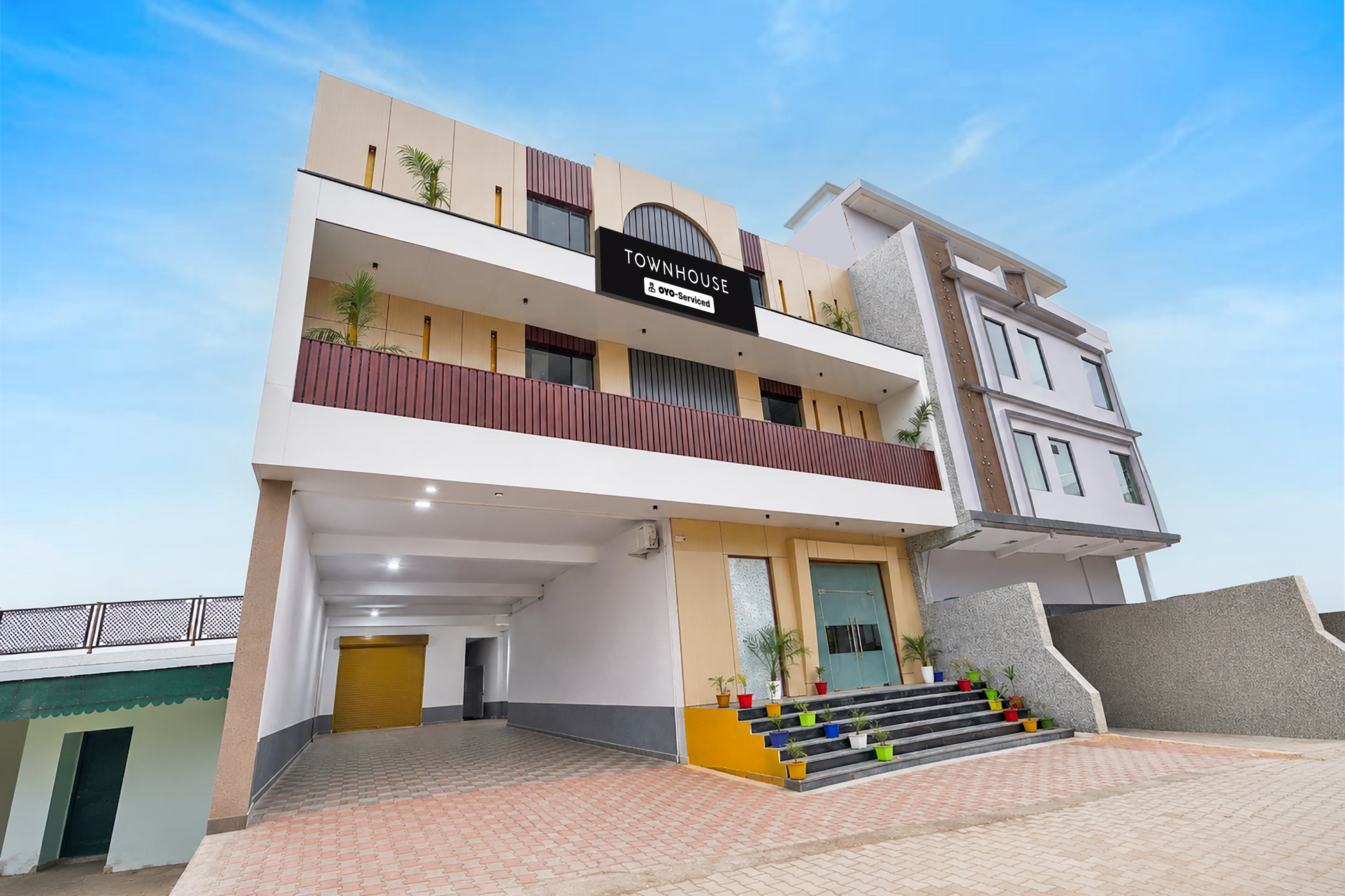 A multi-story building with a sign reading 'TOWNHOUSE' and 'o-v-o Serviced'.