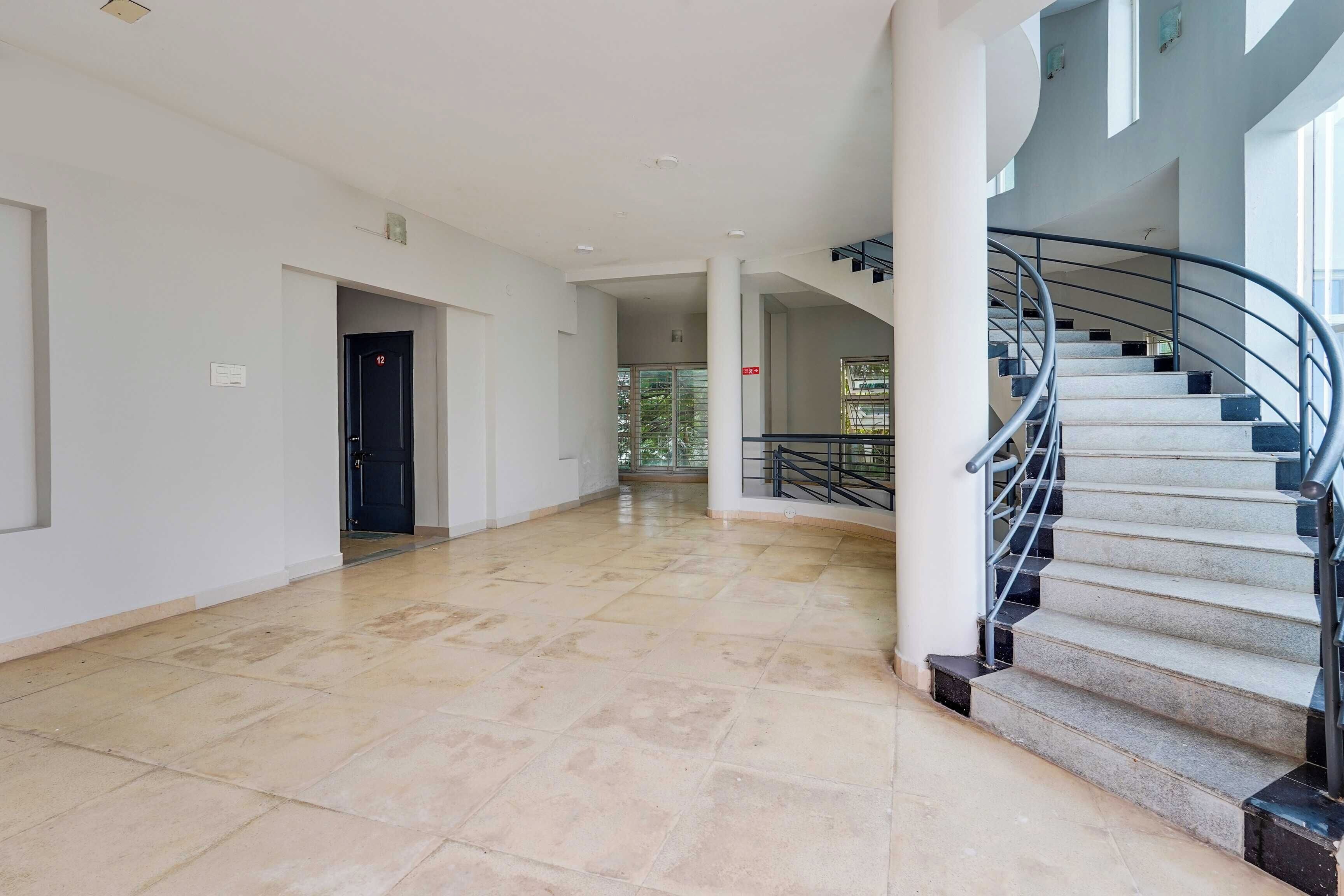 Un interior espacioso con una escalera curva y una puerta marcada con el número 12.