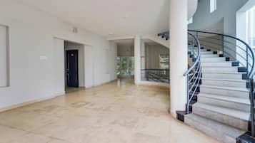 Un interior espacioso con una escalera curva y una puerta marcada con el número 12.