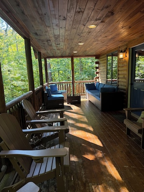 A wooden deck with Adirondack chairs and a sofa, overlooking a forested area. - Secluded Adirondack Lodge, Near Whiteface, Private trails (Jay)