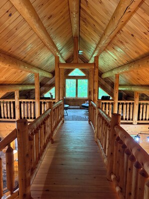 A wooden interior with a central walkway leading to a window overlooking greenery. - Secluded Adirondack Lodge, Near Whiteface, Private trails (Jay)