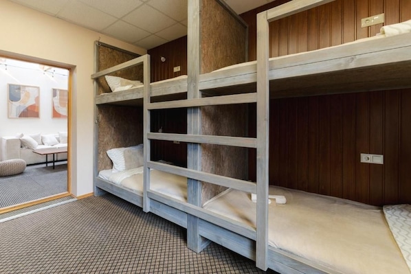 A bunk bed room with a sofa and a patterned floor.