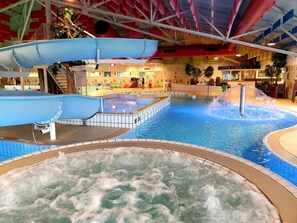 An indoor swimming pool with multiple lanes, a hot tub, and a slide. - Gemütliches Ferienhaus für 2-6 Personen mit privater Hottub in schönen Lochem (Lochem)
