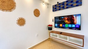 A modern living room with a flat-screen TV mounted on the wall, a wooden console table, and decorative wall art. - 2 Bedroom Bungalow in Nyali (Mombasa)