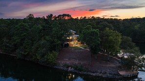 A lakeside property with a two-story building, a dock, and a well-maintained lawn.