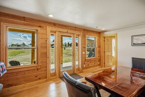 A wooden interior with large windows, a dining table, and a chair. - Fall Escape Special: 15% Discount Ends Nov 30! Must book by Oct 18 (Pagosa Springs)