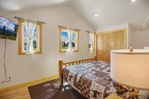 A bedroom with a bed, a wooden headboard, a nightstand, a lamp, and a TV mounted on the wall. - Fall Escape Special: 15% Discount Ends Nov 30! Must book by Oct 18 (Pagosa Springs)