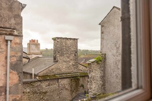 Ein Steinhaus mit traditioneller Bauweise, mit Schornstein und einem moosbewachsenen Dach.