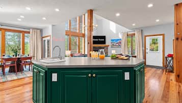 A spacious kitchen with a central island, wooden cabinets, and a dining area with a table and chairs.