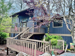 A two-story building with a wooden deck and a flag. - Mountainview Manor with VIEWS GALORE in Beech Mountain close to the ski slopes (Beech Mountain)