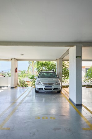 A parking garage with a car parked in a designated spot marked with the number 305. - Apartment in Condominium Itagua Viewpoint - Between Praia Grande and Tenório - 10 min walk (Ubatuba)