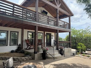 A two-story house with a covered porch, outdoor seating, and a stone pathway leading to the entrance. - The Fort Worth Overlook (Fort Worth)