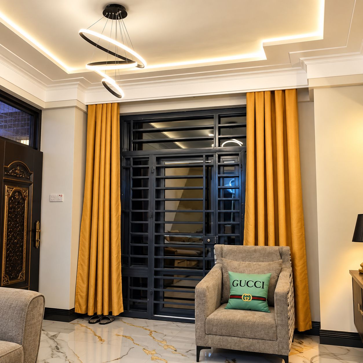 Un interior moderno con un sofá, un cojín decorativo, un portón negro y cortinas amarillas.