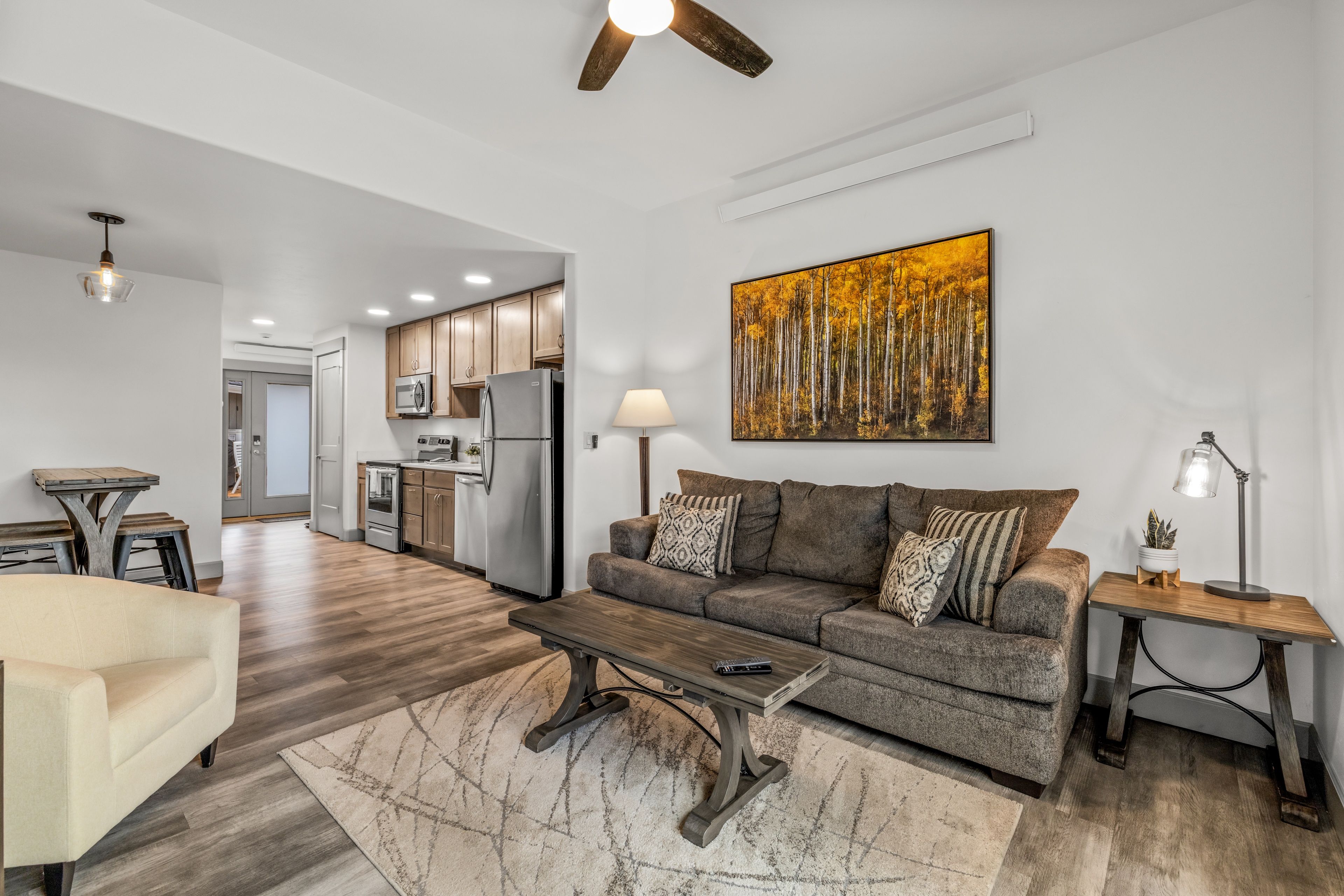 A modern living room with a sofa, coffee table, and a painting on the wall.