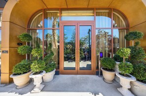 A hotel entrance with a glass door, potted plants, and a 'NO SMOKING' sign. - Cozy 1BR- Pool -Steps to Wynwood Walls (Miami)
