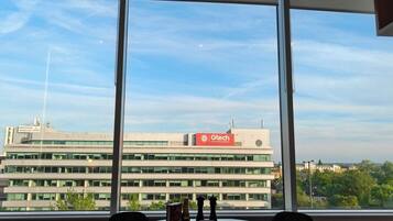A view from a window with a table and chairs, overlooking a building with a sign reading 'Gtech Community Stadium.'