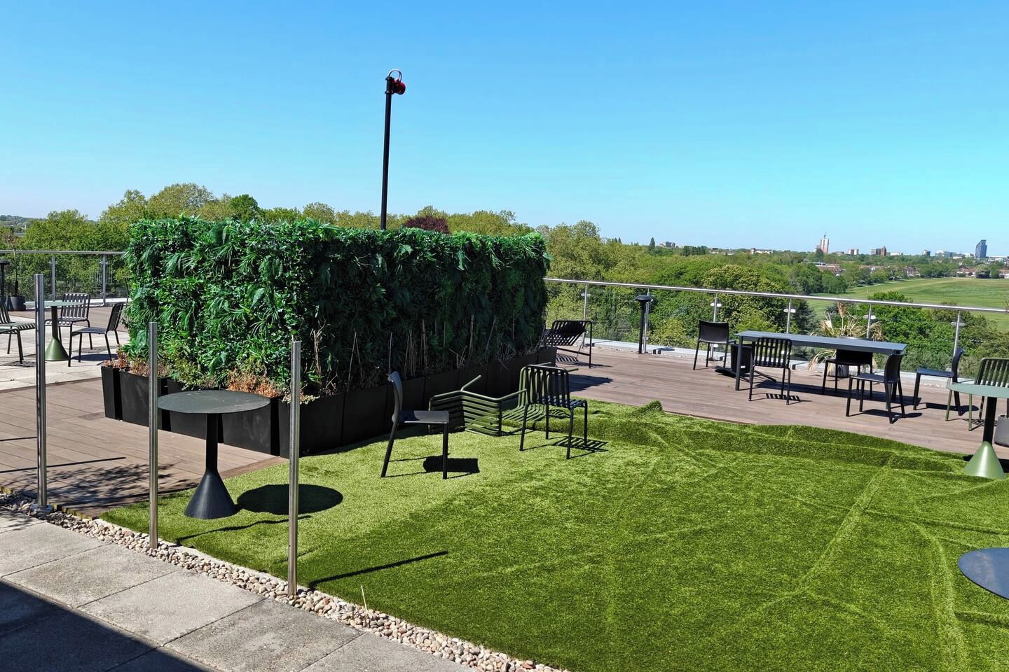An outdoor patio area with seating and a view of the city.