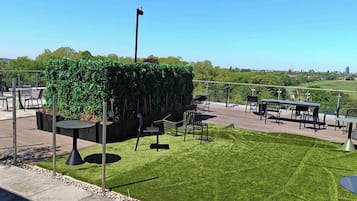 An outdoor patio area with seating and a view of the city.