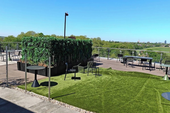 An outdoor patio area with seating and a view of the city.