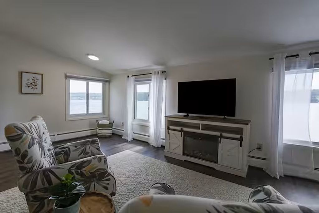 Un salon avec un téléviseur à écran plat, un canapé, une table basse et une plante en pot.