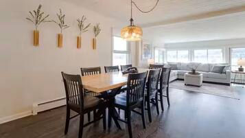 A dining area with a wooden table and chairs, a chandelier, and wall-mounted planters.