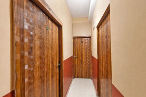 A corridor with wooden doors, each marked with a number. - Classic The Suncity Hotel (Patna)