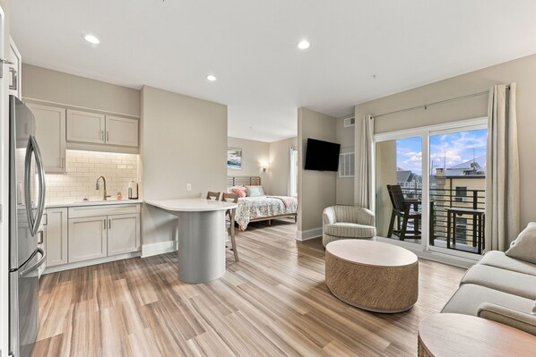 Eine moderne Wohnung mit Küche, Essbereich und einem Balkon mit Aussicht.