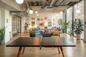 A modern interior with a ping pong table, seating area, and artwork on the walls. - Wembley Park 1 Bed | Sleep 4 | Gym, Workspace (Greater London)