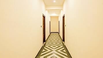 A long, narrow hallway with a patterned floor and doors on either side.