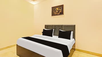 A hotel room with a bed, a headboard, a wall-mounted artwork, and a tiled floor.