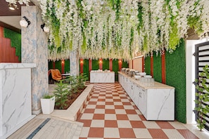 Un vestíbulo de hotel con piso a cuadros, una recepción y una pared verde con elementos verticales.