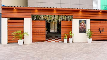 A building facade with a wooden panel design, a checkered floor pattern, and potted plants.