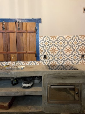 A kitchen with a wooden cabinet, a sink, and patterned tiles.