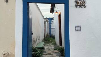 Une ruelle étroite avec un cadre de porte bleu, un chemin pavé et un numéro, « 38 », peint sur le mur.
