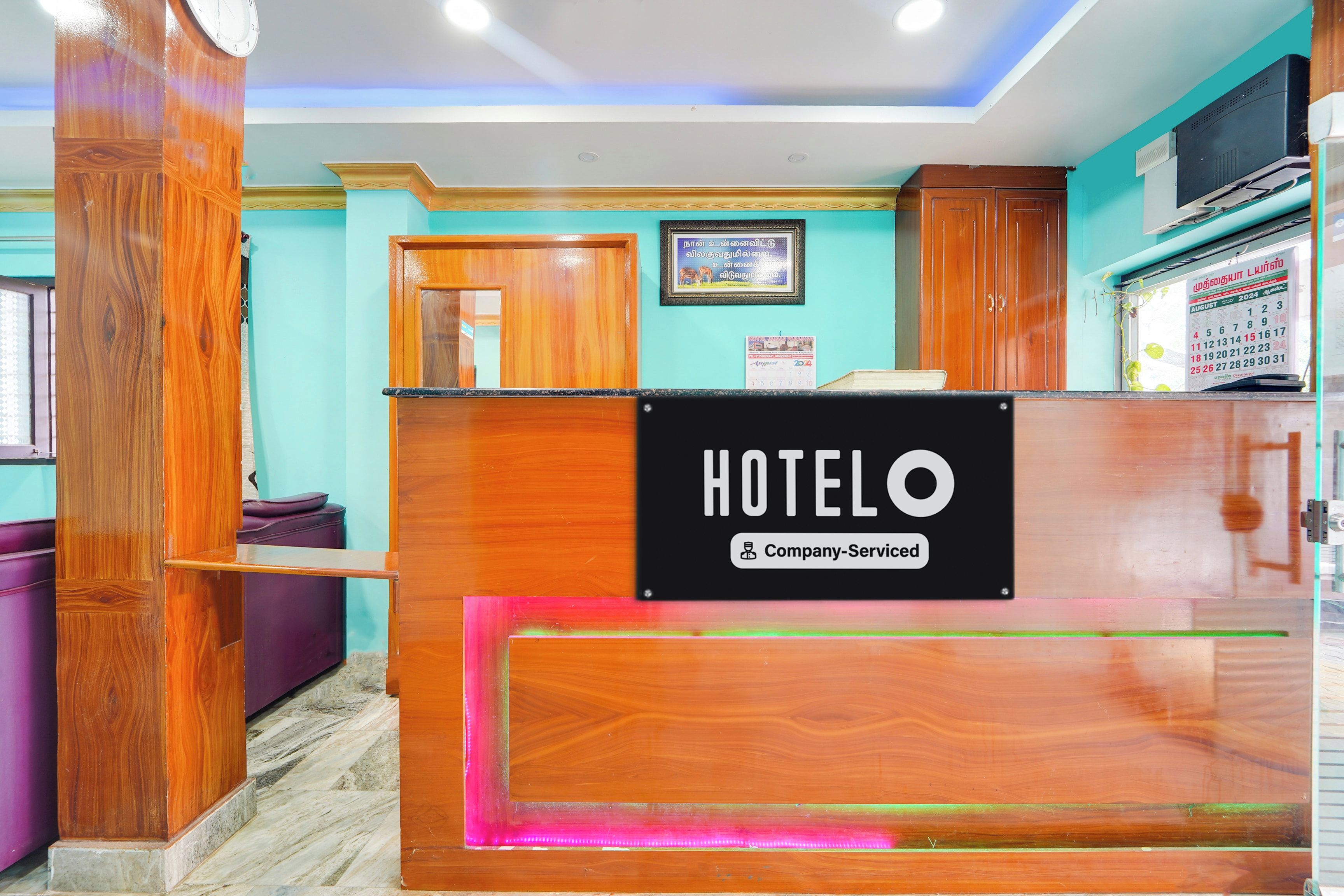 A hotel reception desk with a sign indicating it is a company-serviced hotel.