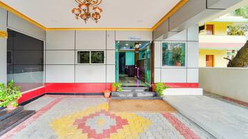 A hotel entrance with a tiled floor, a clock, and a welcome sign.