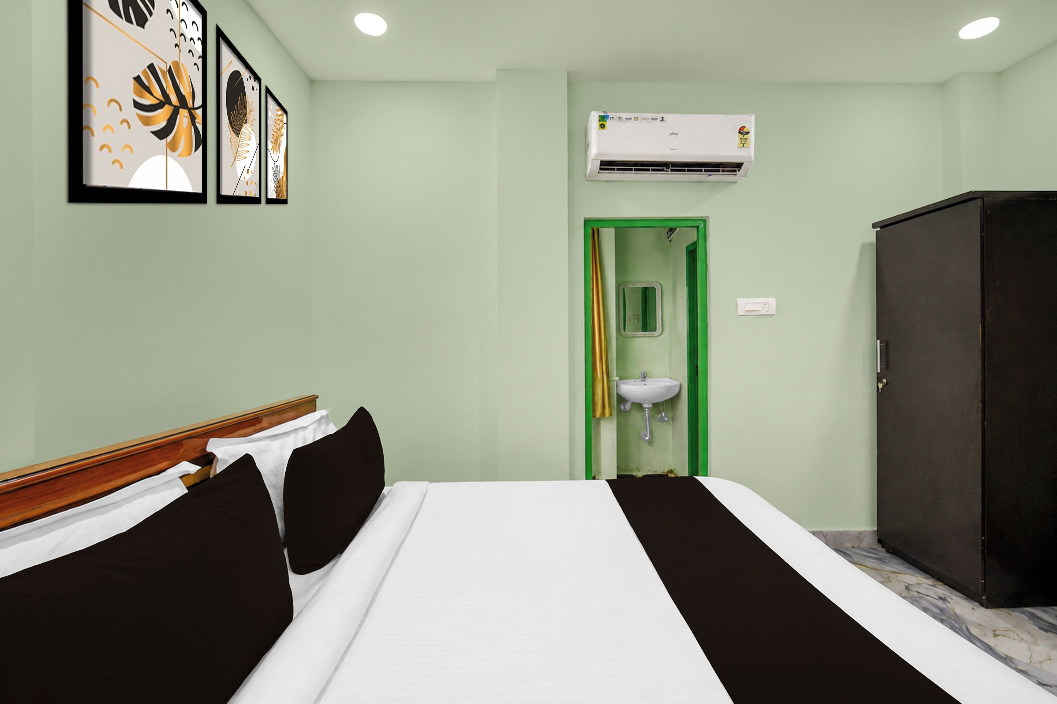 Una habitación de hotel con cama, armario, lavamanos y aire acondicionado.