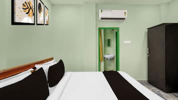 Una habitación de hotel con cama, armario, lavamanos y aire acondicionado.