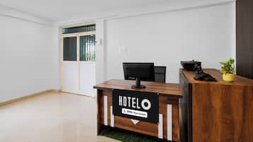 Un mostrador de recepción de hotel con un cartel que indica que es atendido por OYO.