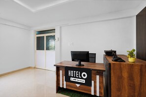 Taulell de recepció d'hotel amb un cartell que indica que ofereix servei de OYO.