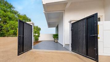 A gated entrance to a building with a covered walkway leading to a door.