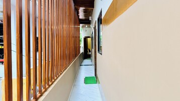 Un pasillo con una cerca de madera a un lado y una pared blanca al otro.