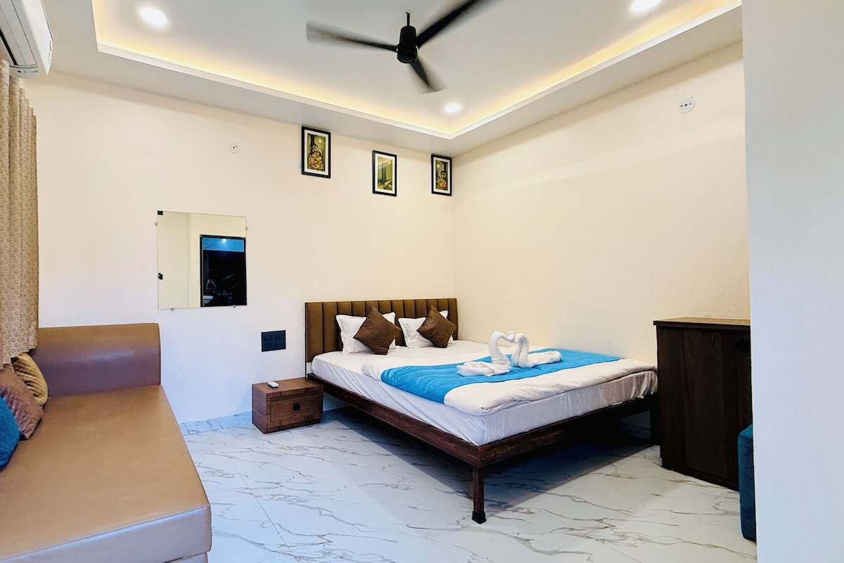 Un dormitorio con cama, sofá, ventilador de techo y espejo.
