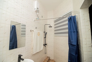 A bathroom with a shower, a towel rack, a mirror, and a toilet. - NK Luxury Hotel DN (Accra)